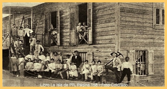 Primer día de clases en el Instituto de Agricultura, Artes y Oficios (IAAO) en barrio Palmarejo. A la derecha don Juan Cancio Ortiz, con picota al hombro, la persona que fundó y desarrolló la idea, de lo que hoy se conoce como la Universidad Interamericana.